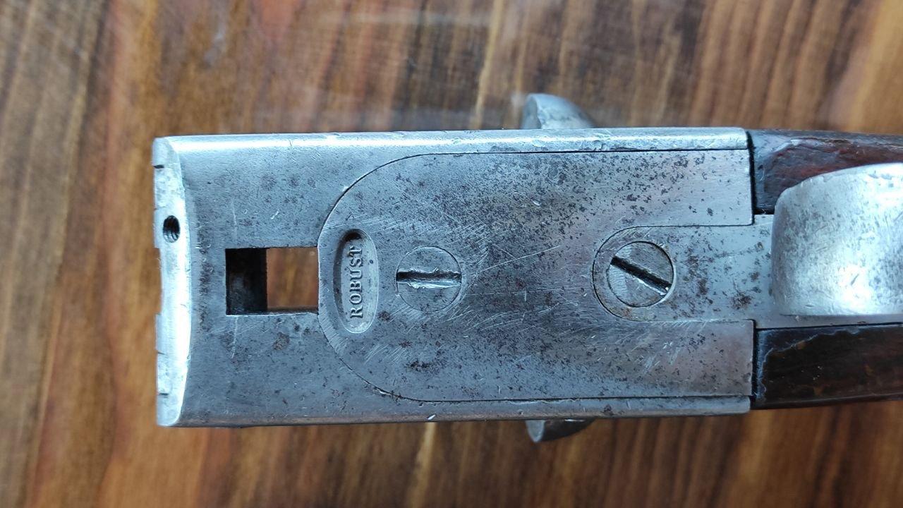 Review of the French shot gun, the ROBUST, manufactured in 1913, featuring a 12 gauge, English stock, and reinforced barrels.