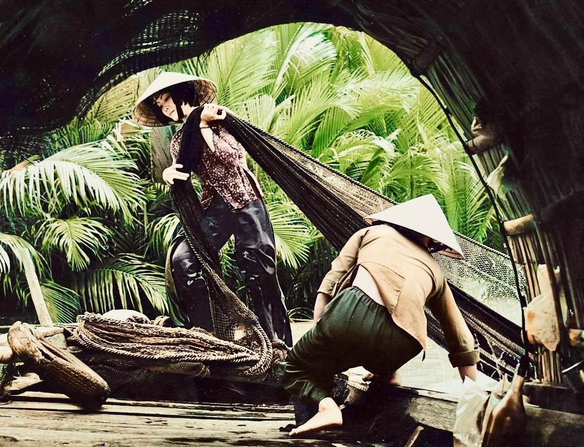 Female fishermen take out nets from the Mekong River.